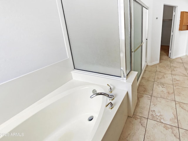bathroom featuring a shower stall, a bath, and a spacious closet