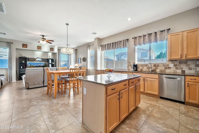 kitchen featuring dishwasher, a center island, sink, and dark stone counters