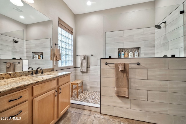 bathroom with vanity and tiled shower