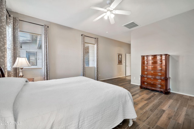 bedroom featuring multiple windows, dark hardwood / wood-style floors, and ceiling fan