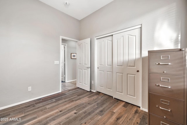 unfurnished bedroom featuring dark hardwood / wood-style flooring and a closet