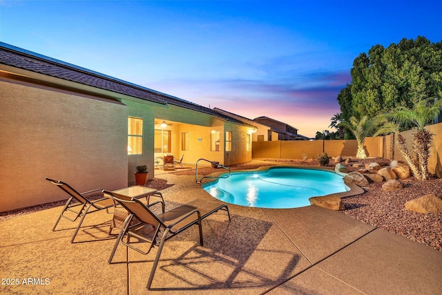 pool at dusk with a patio