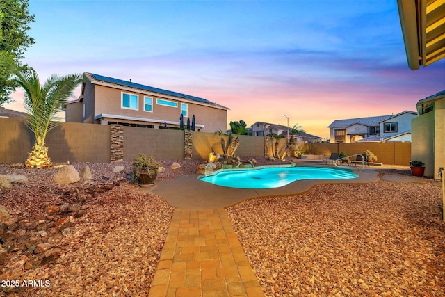 pool at dusk featuring a patio