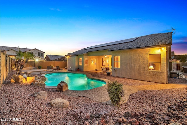 pool at dusk with a patio area