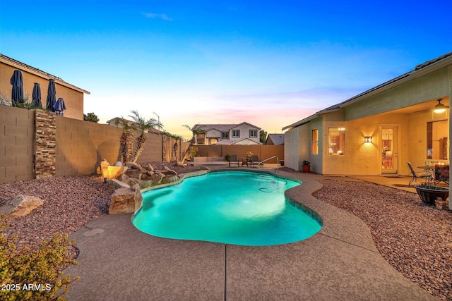 pool at dusk with a patio area