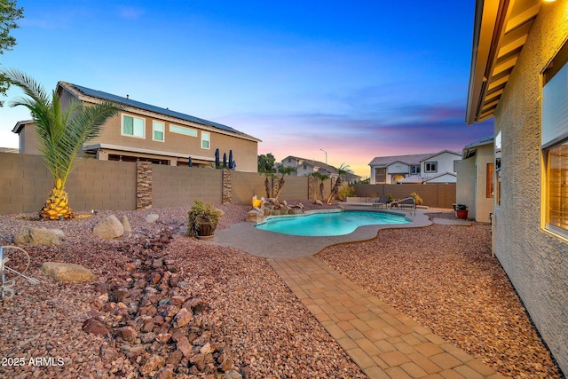 pool at dusk with a patio area