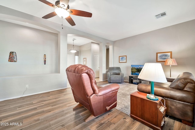 living room featuring wood-type flooring and ceiling fan