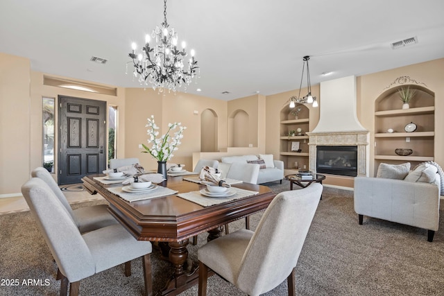 dining room with baseboards, a fireplace, visible vents, and built in features