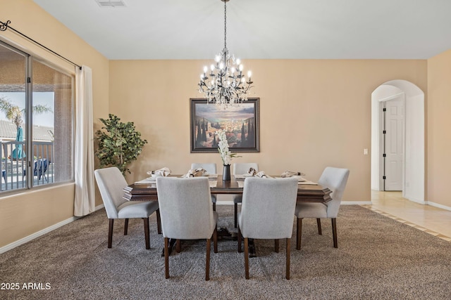 dining room featuring baseboards, visible vents, arched walkways, carpet floors, and a chandelier