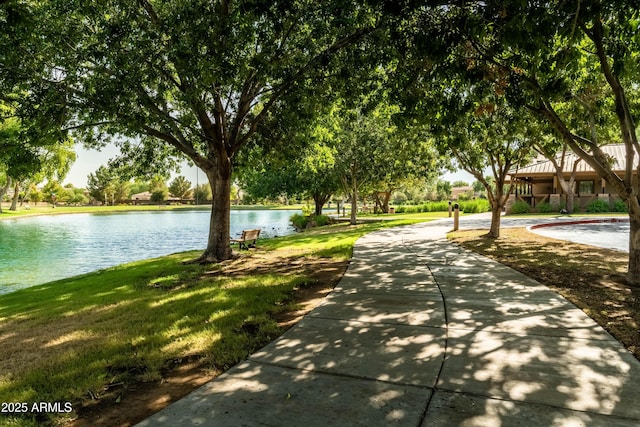 view of property's community with a water view and a yard