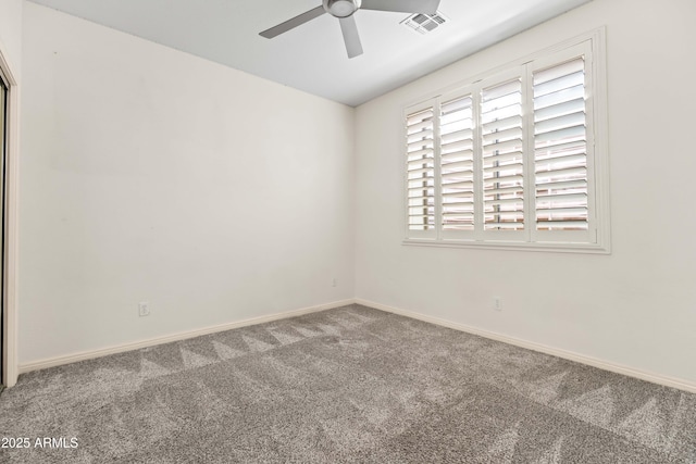 spare room featuring carpet floors, a ceiling fan, visible vents, and baseboards