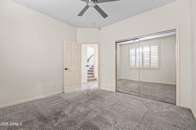 unfurnished bedroom with ceiling fan, a closet, carpet flooring, and baseboards