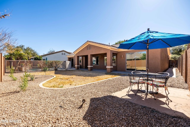 rear view of house with a patio, a fenced backyard, a tiled roof, and stucco siding