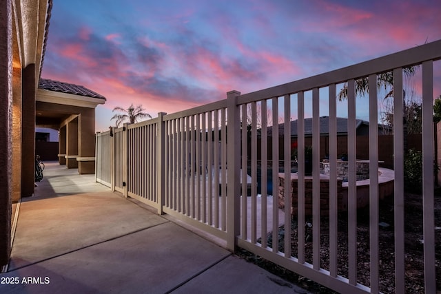 gate at dusk with a patio area