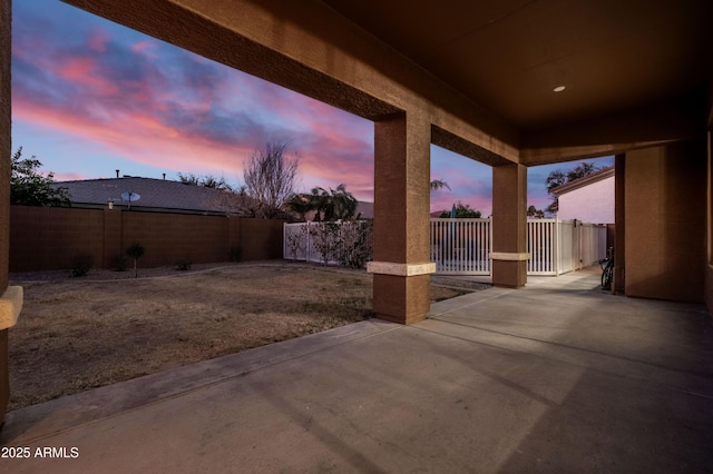 patio terrace at dusk with a fenced backyard