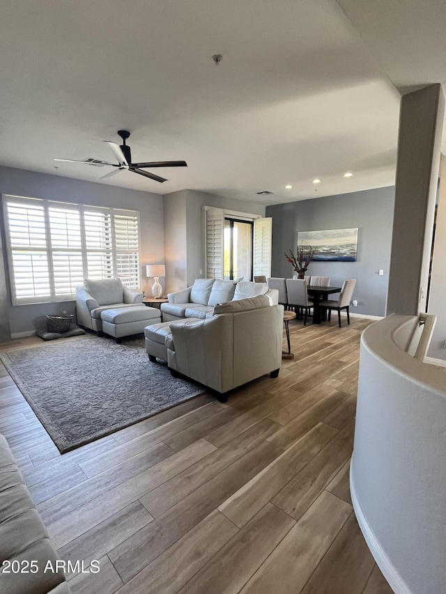 living room with a ceiling fan, recessed lighting, and wood finished floors