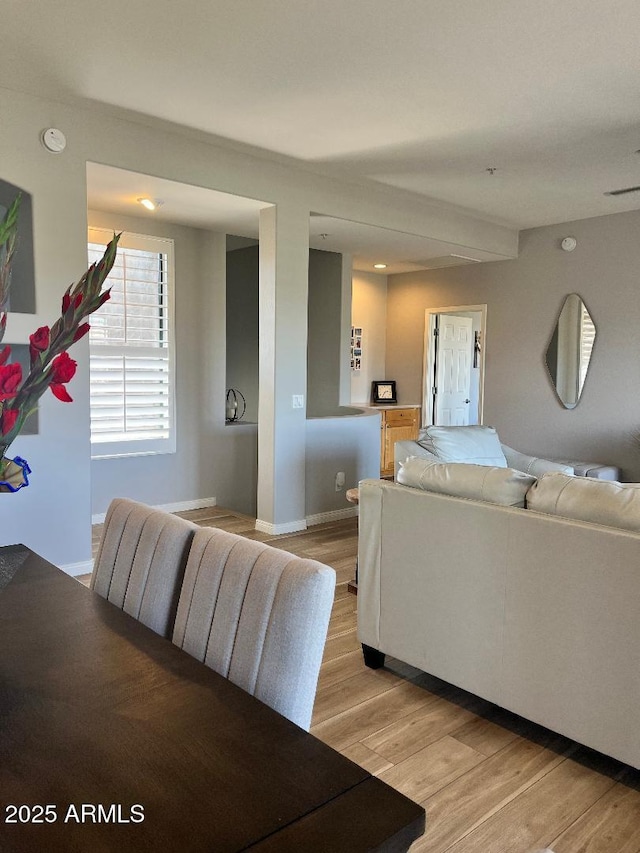 living area featuring baseboards and light wood-type flooring