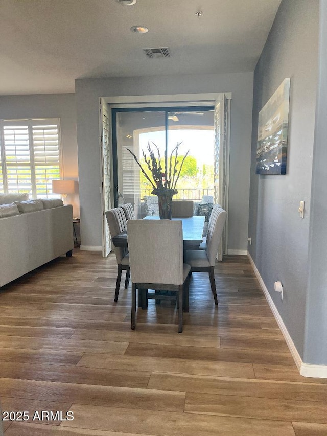 dining area featuring baseboards, wood finished floors, and visible vents