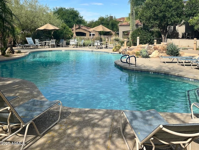community pool with fence and a patio