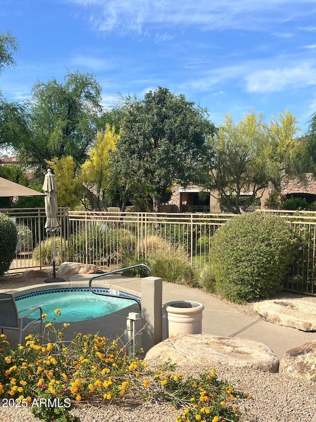 view of swimming pool featuring an in ground hot tub and fence
