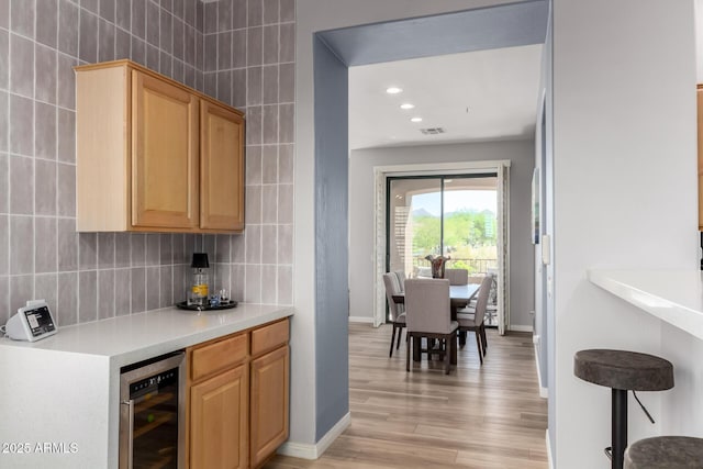 19550 N Grayhawk Dr Unit 2023, Scottsdale, AZ 85255 - indoor dry bar featuring beverage cooler, light wood-style flooring, tasteful backsplash, baseboards, and recessed lighting