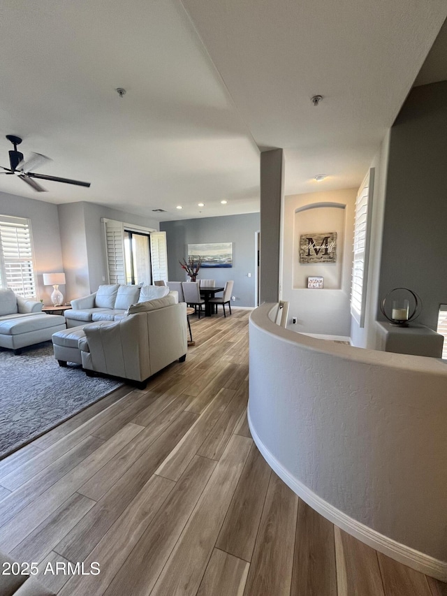 living room with a ceiling fan, baseboards, a healthy amount of sunlight, and wood finished floors