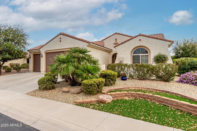 mediterranean / spanish-style home featuring a garage, driveway, a tile roof, and stucco siding