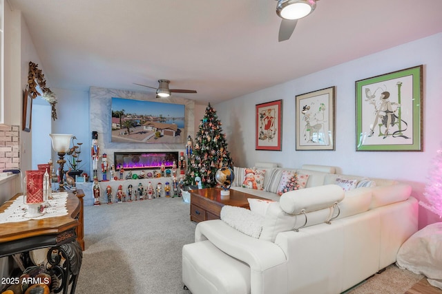 carpeted living room featuring ceiling fan and a fireplace