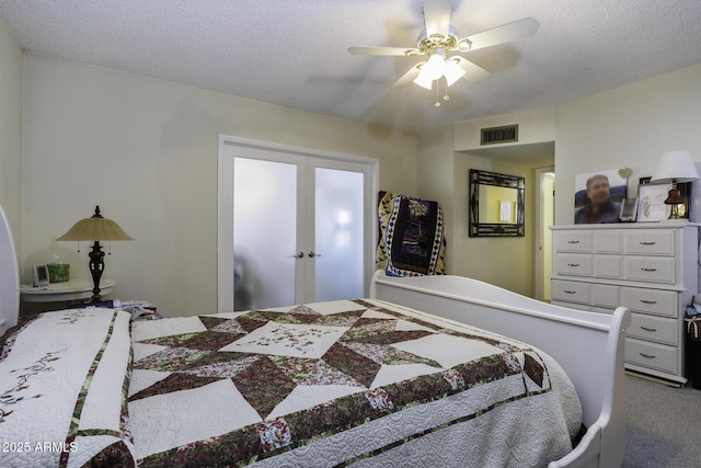 carpeted bedroom with ceiling fan and a textured ceiling