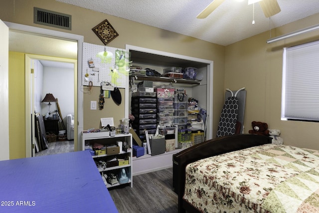 bedroom with hardwood / wood-style flooring, ceiling fan, a textured ceiling, and a closet