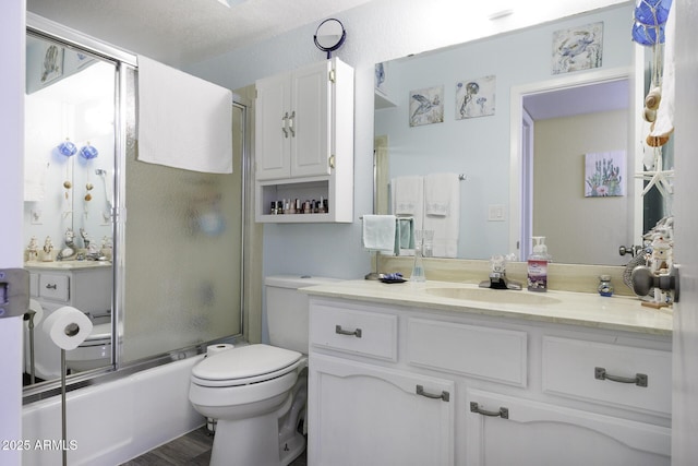 full bathroom featuring enclosed tub / shower combo, a textured ceiling, toilet, vanity, and hardwood / wood-style flooring