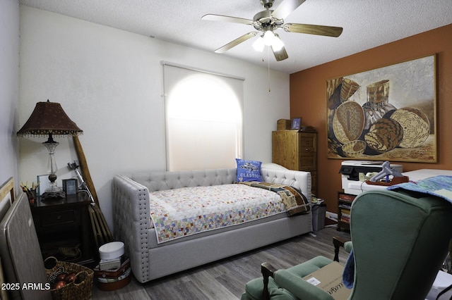 bedroom featuring ceiling fan, wood-type flooring, and a textured ceiling