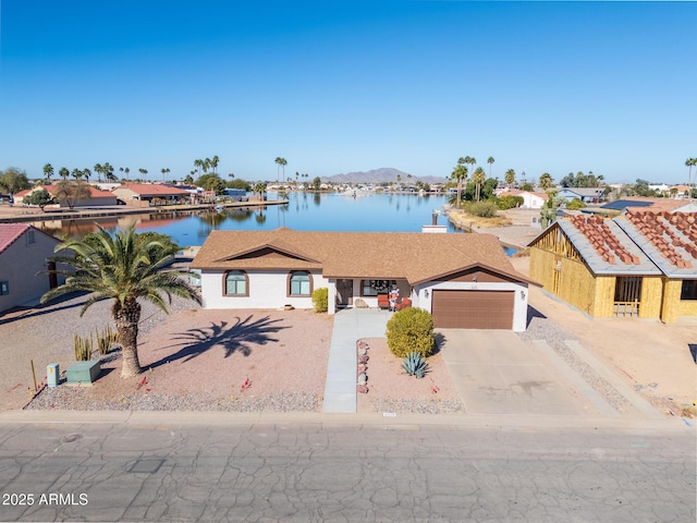 view of front of home with a garage and a water and mountain view