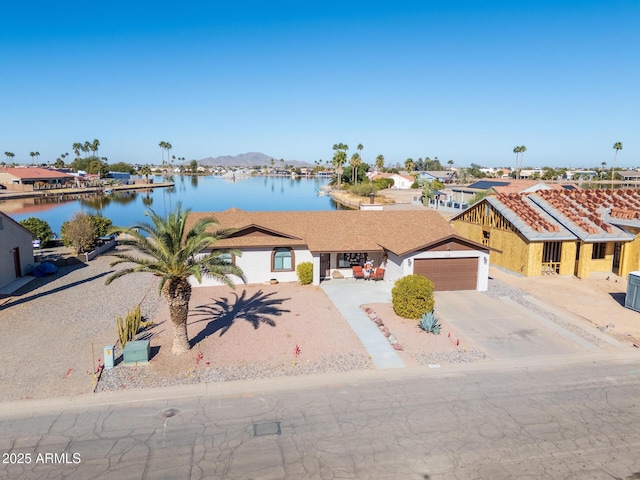 view of front of property with a water and mountain view and a garage