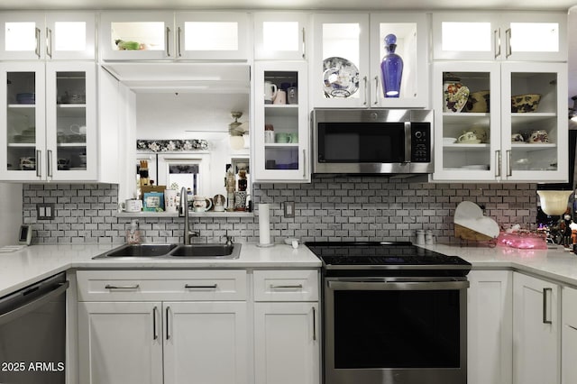 kitchen featuring decorative backsplash, sink, white cabinetry, and stainless steel appliances