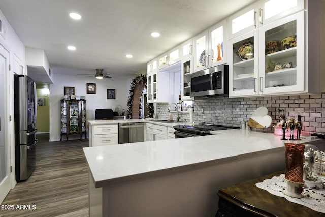 kitchen with kitchen peninsula, ceiling fan, white cabinets, and stainless steel appliances