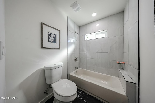 bathroom featuring tiled shower / bath combo and toilet