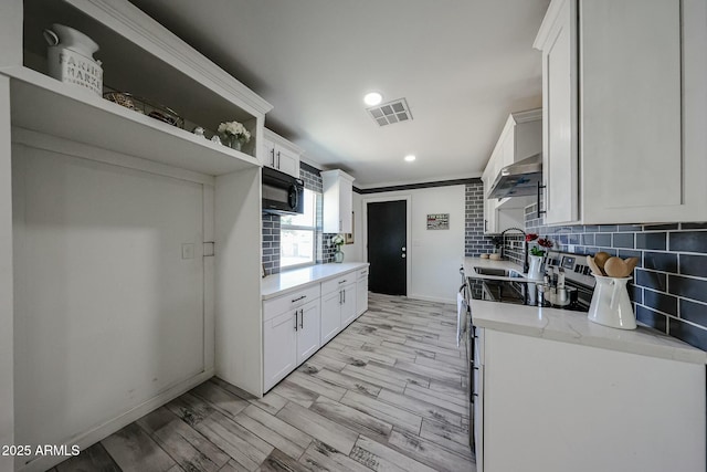 kitchen featuring white cabinetry, light stone countertops, and backsplash