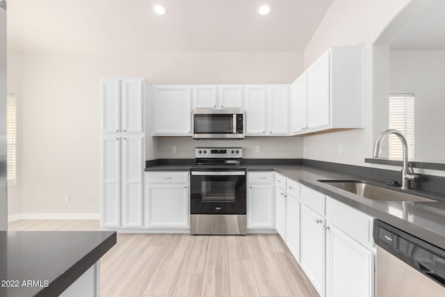 kitchen with light hardwood / wood-style flooring, stainless steel appliances, sink, and white cabinetry