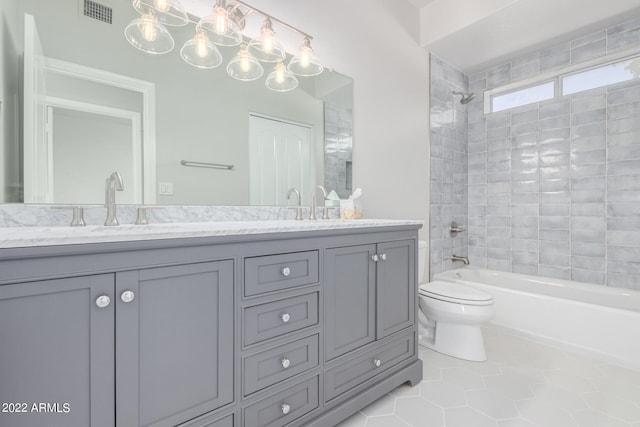 full bathroom with vanity, tile patterned flooring, toilet, and tiled shower / bath combo