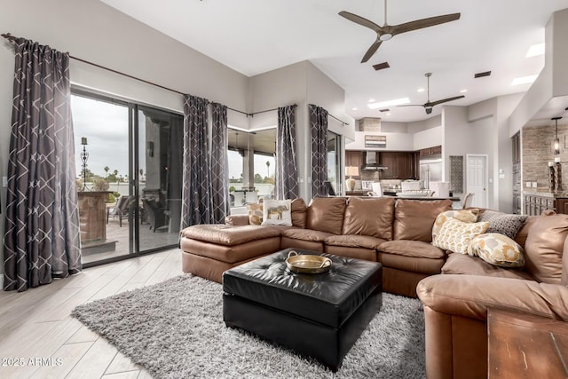 living area with a wealth of natural light, visible vents, and ceiling fan