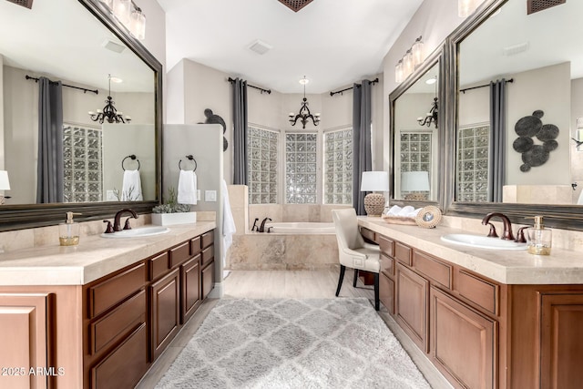 bathroom featuring a sink, two vanities, and a chandelier