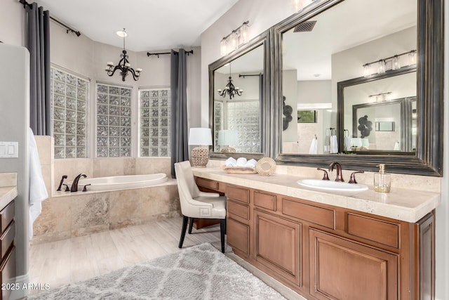 full bath featuring vanity, an inviting chandelier, a bath, and visible vents