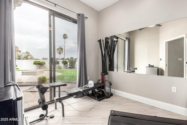 workout area with ceiling fan and baseboards