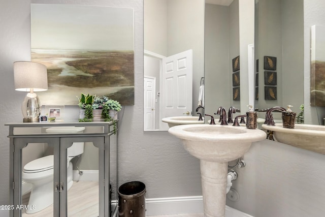 bathroom with baseboards and toilet