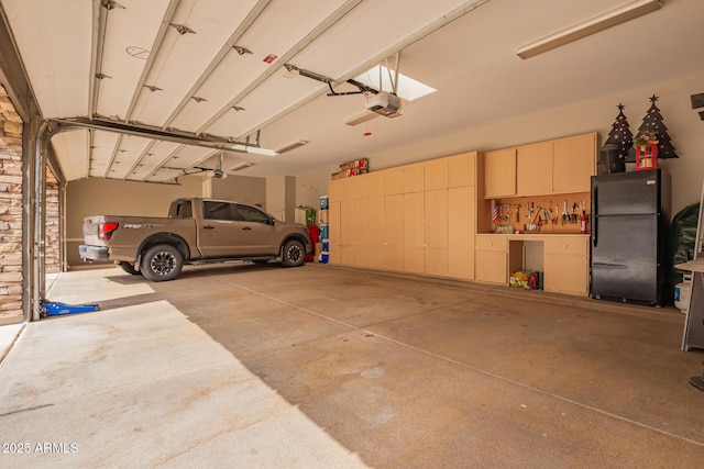 garage with a garage door opener and freestanding refrigerator