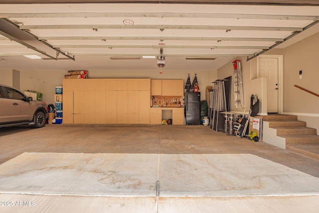 garage featuring a garage door opener and freestanding refrigerator