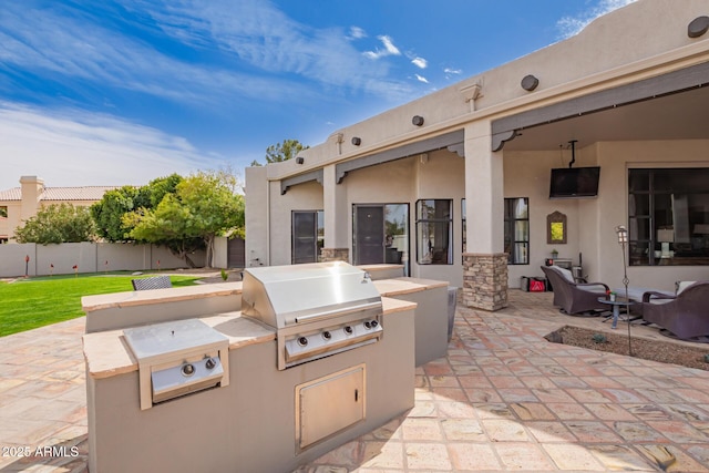 view of patio / terrace featuring area for grilling, fence, and a grill