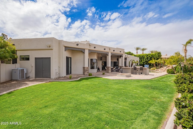 back of property featuring a patio, a yard, outdoor dry bar, and stucco siding