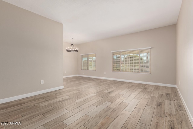 unfurnished room with light hardwood / wood-style floors and a notable chandelier